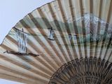 a fan with a painting of boats on it