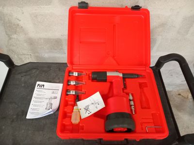 une mallette rouge contenant des outils, posée sur une table