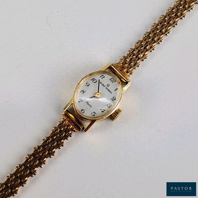 une image d'un gros plan d'une montre-bracelet sur une surface blanche