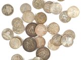 an assortment of silver and bronze coins on a white surface