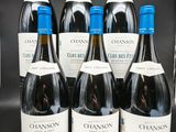 six bouteilles de vin rouge sont alignées