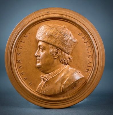 a close up of a bronze medallion with a man wearing a hat