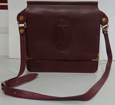 sac à main en cuir bordeaux avec des détails dorés et une bandoulière