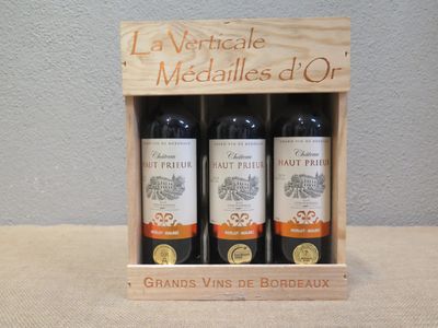 trois bouteilles de vin dans un coffret en bois sur une table