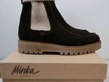 Il y a une paire de bottes noires posée sur la boîte.