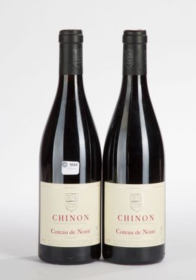 two bottles of red wine sitting next to each other on a white surface