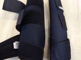 two pairs of knee pads on a table next to a bottle of water