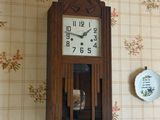 une horloge accrochée au mur, à côté d'une assiette accrochée au mur