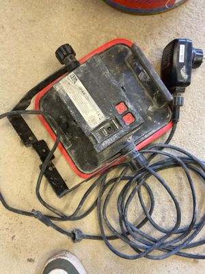a red and black corded device sitting on the floor next to a mouse