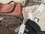 a purse and a pair of pants sitting on a bed