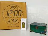 a box with a clock on it next to a box with a green suitcase