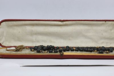 a bead necklace in a red case with a pair of scissors