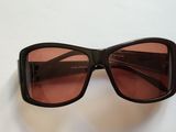 des lunettes de soleil noires aux verres roses sur un fond blanc