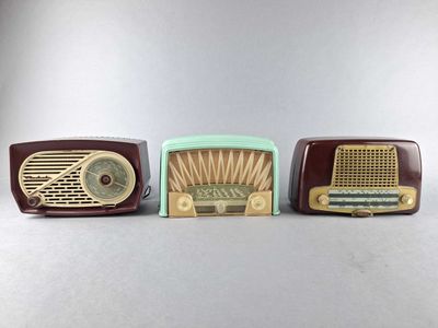 three old fashioned radio ' s are lined up on a table