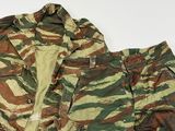 une photo d'une veste et d'un pantalon de camouflage posés sur une surface blanche
