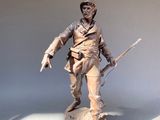 statue d'un homme tenant un fusil, posée sur une surface blanche
