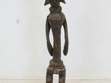 an old wooden statue of a person sitting on a stool