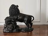 a statue of a lion on a wooden table