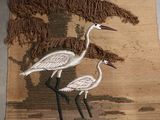 two birds that are standing on a rug on the floor
