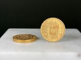 une pièce d'or posée à côté d'une petite pièce d'or