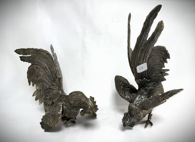 two metal birds that are standing next to each other