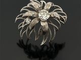 Gros plan sur une bague en argent ornée d'une fleur