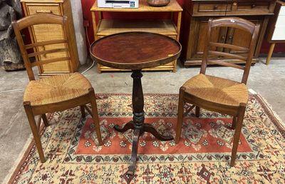 trois chaises et une table posées sur un tapis dans une pièce
