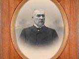 an old photo of a man in a suit and tie in a wooden frame