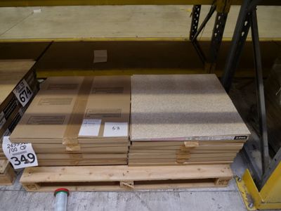 Plusieurs piles de bois sont empilées sur des palettes dans un entrepôt