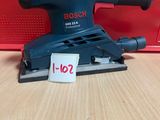 une ponceuse orbitale Bosch posée sur une table, avec son étiquette de prix