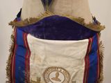 a blue and white sash with a gold emblem on it