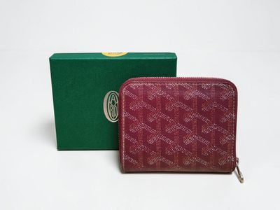 a red and green wallet sitting next to a green box