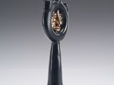 a black vase with a face in the middle of it