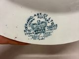 someone is holding a white plate with a blue crown on it