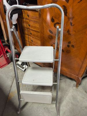 a metal step stool with two steps on top of it