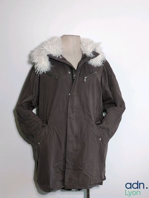 une veste à capuche posée sur un mannequin contre un mur blanc