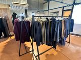 clothing racks in a clothing store with clothes hanging on them