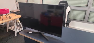 une télévision à écran plat posée sur un bureau dans une pièce