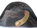 a black hat with a gold band on top of it