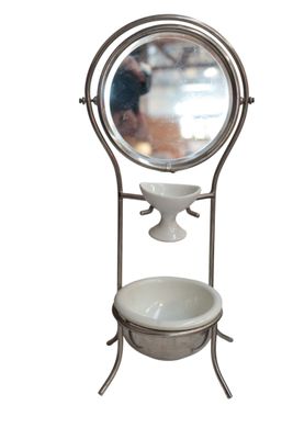 a mirror on a stand with a bowl and a bowl on it