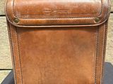 brown leather briefcase sitting on top of a black table