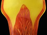 a vase with a leaf design on it on a black background