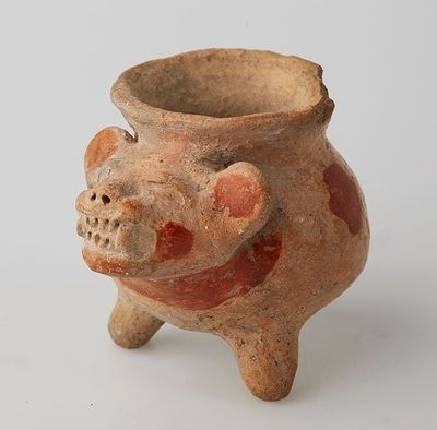 a clay pot with a pig decoration on it