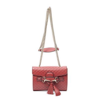 un sac à main rouge avec une bandoulière en chaîne et un pompon
