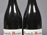 two bottles of red wine sitting next to each other on a table