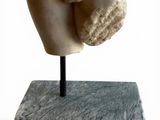 marble statue of a female torso on a stand on a white background