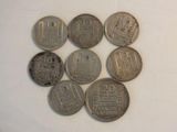 six silver coins sitting on top of each other on a white surface