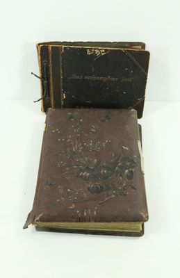 un vieux livre posé sur une table blanche à côté d'un livre noir