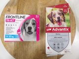 Deux boîtes d'Advantix sont posées sur une table, à côté de la tête d'un chien.