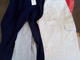 trois paires de pantalons posées sur une palette dans un magasin